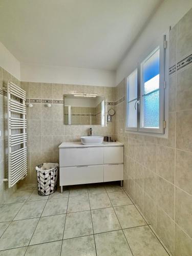 une salle de bain avec un lavabo blanc et un miroir dans l'établissement L'Escapade, Quartier Calme, Proche Bord de Mer, à Meschers-sur-Gironde