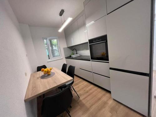 a kitchen with a table with chairs and a refrigerator at Villa Naledi in Pašman