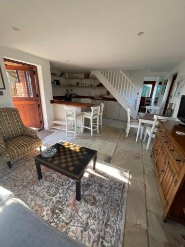 a living room with a coffee table and a staircase at The Old Poor House Coach House in Sidlesham