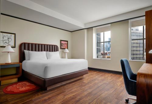a bedroom with a bed and a desk and two windows at Hotel Indigo Nashville - The Countrypolitan in Nashville