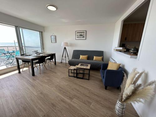 un salon avec un canapé bleu et une table dans l'établissement 2 pièces avec balcon, 4 couchages à Saint-Jean-de-Monts - FR-1-224C-319, à Saint-Jean-de-Monts