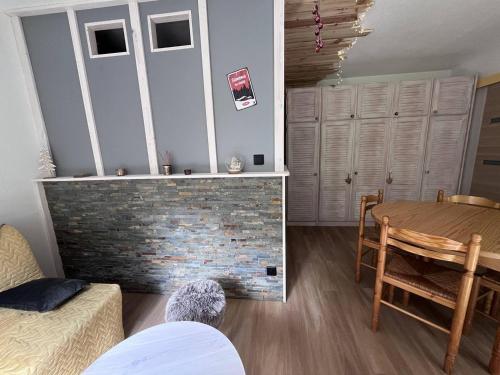 - un salon avec une table et une cheminée en briques dans l'établissement Charmant chalet 4 pers. à Cauterets avec parking - FR-1-812-113, à Cauterets