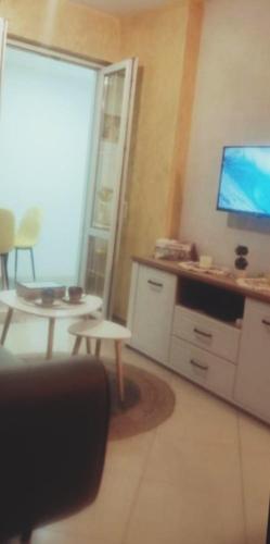 a living room with a tv and a table and a chair at Stan Rafailovici LM in Rafailovici