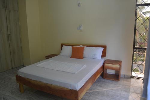 a bedroom with a bed and a chair in it at Lulu Homestay in Mombasa