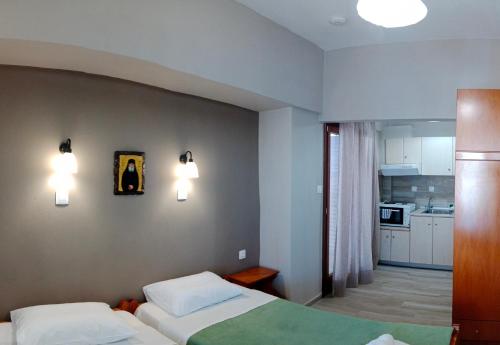una camera da letto con due letti e due lampade a parete di Prosforio Rooms a Ouranoupoli