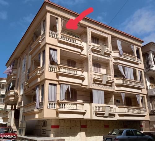 a building with a red arrow on it at شقة مفروشة للإيجار بمصيف رأس البر سادس مطل من البحر 1 in Ras El Bar