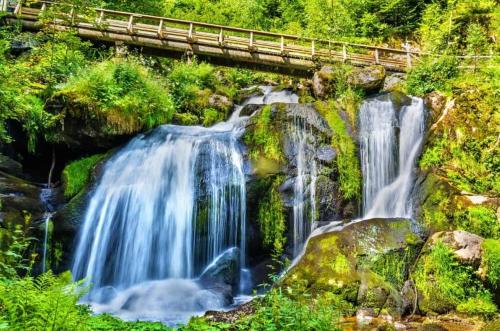 a waterfall with a bridge on top of it at Haus Steiner #Mitten im Schwarzwald# in Lauterbach