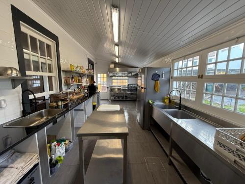 a large kitchen with stainless steel counters and sinks at Golden Mermaid Villa, Big Home Amenities - Small Hotel Room Price in Ribeira Grande