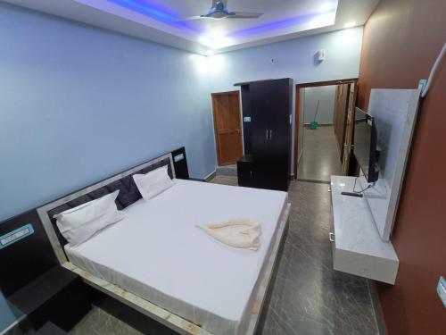 a bedroom with a white bed and a mirror at Kashvi Palace in Muzaffarpur