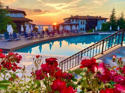 a large swimming pool with flowers in front of a resort at AJ Apartment 8, Santa Marina Holiday Village, Sozopol in Sozopol