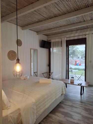 a bedroom with a bed and a table and a window at Valia's Beach Studios in Samos