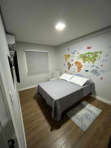a bedroom with a bed with a map on the wall at Quarto privativo em Brusque próximo ao hospital e centro in Brusque
