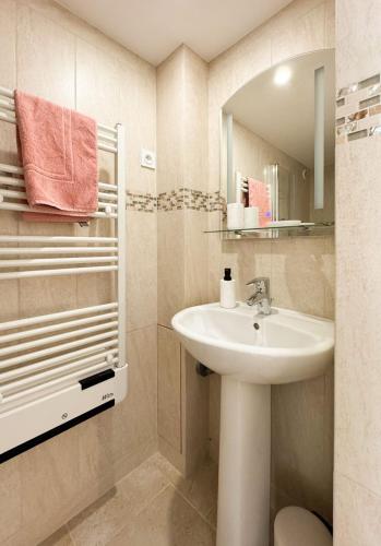 une salle de bain avec un lavabo et un miroir dans l'établissement La petite maison, à Noyers-sur-Serein