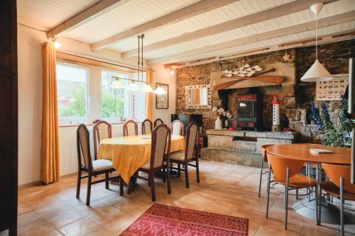 une salle à manger avec une table et des chaises et une cheminée dans l'établissement Maison partagée - Moulin de Kerellec, à Plougoulm