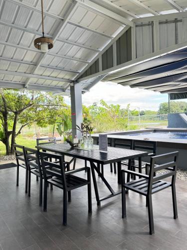 a dining table and chairs on a patio at The MIAGE Resthouse in Baliuag