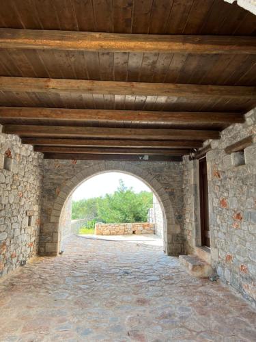 an archway in a stone building with a wooden ceiling at Koukouri Village in Kafióna