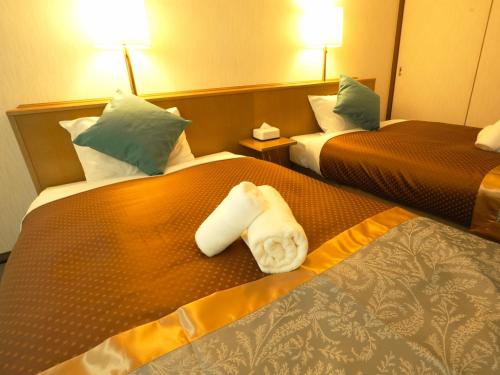 Postel nebo postele na pokoji v ubytování ロイヤルシティホテル Royalcity Hotel