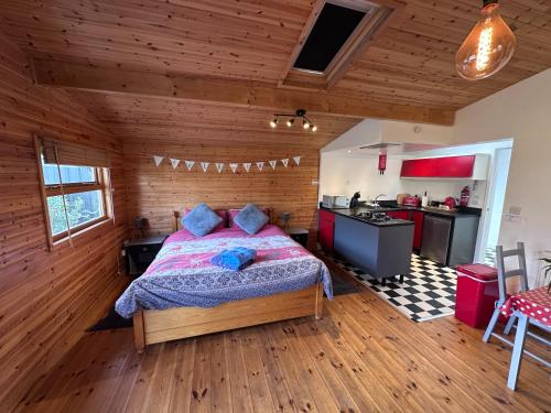 a bedroom with a bed in a wooden room at The Little Lodge is a cosy luxury hideaway.. in Gaerwen