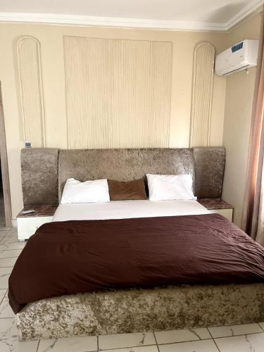 a bedroom with a large bed with a brown blanket at The cozy spot by Jules - 1 bedroom in Katampe in Mobushipe