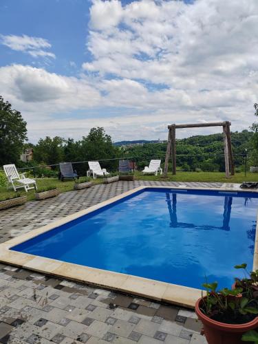 a large blue swimming pool with two chairs on a patio at Kuća za odmor Pinka House in Sveti Ivan Zelina
