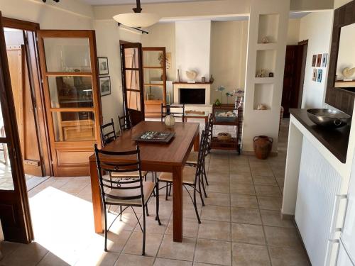 a kitchen and dining room with a wooden table and chairs at Amazing seaside beach home in the best location in Agios Ioannis Pelio