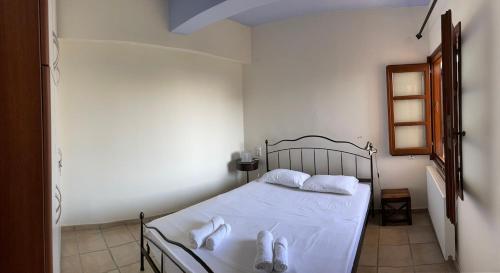 a bedroom with a bed with white sheets and towels at Amazing seaside beach home in the best location in Agios Ioannis Pelio