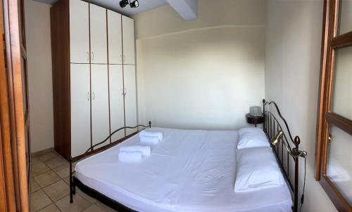 a bedroom with a bed with two towels on it at Amazing seaside beach home in the best location in Agios Ioannis Pelio