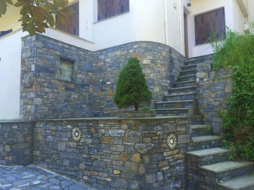a stone wall with a tree on top of it at Amazing seaside beach home in the best location in Agios Ioannis Pelio