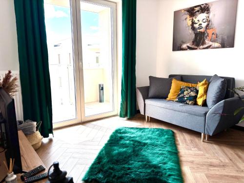 Una sala de estar con un sofá y una ventana grande. en Ami Luxury Residence XII CENTRUM - możliwość REJSU ŁODZIĄ, en Iława