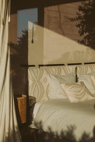 a bed with white pillows in a room at Casa da Ria in Tavira