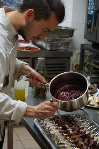 Un homme remue un gâteau au chocolat dans un pot dans l'établissement auberge des trois ami-es, à Vinezac