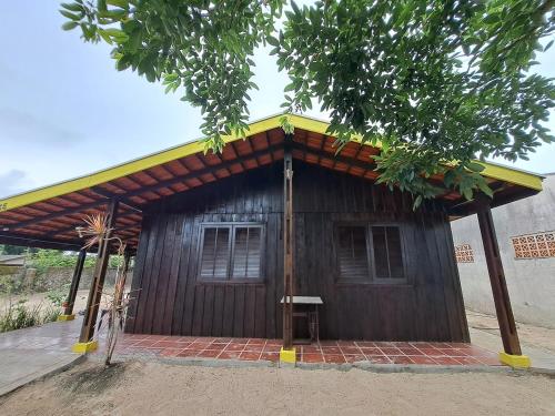 a small wooden building with a yellow roof at Casa com Piscina, Churrasqueira e Quadra de Vôlei! in Pontal do Paraná