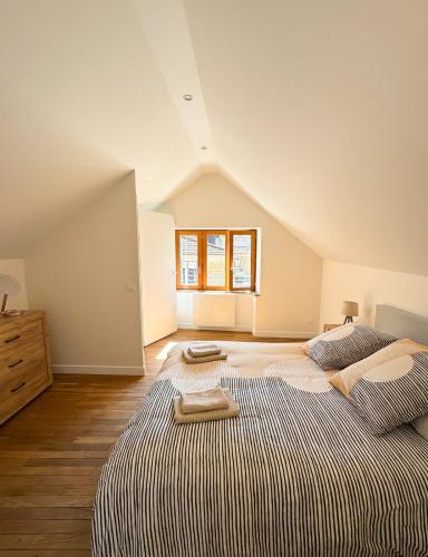 - une chambre mansardée avec 2 lits et une fenêtre dans l'établissement La petite maison, à Noyers-sur-Serein