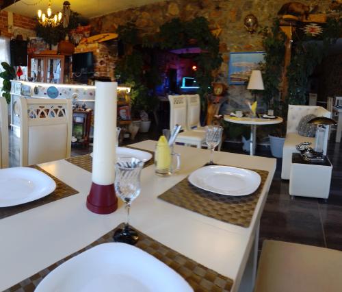 a table with white plates and a candle on it at Hotel Villa Stone Dream Bar Restaurant in Pogradec