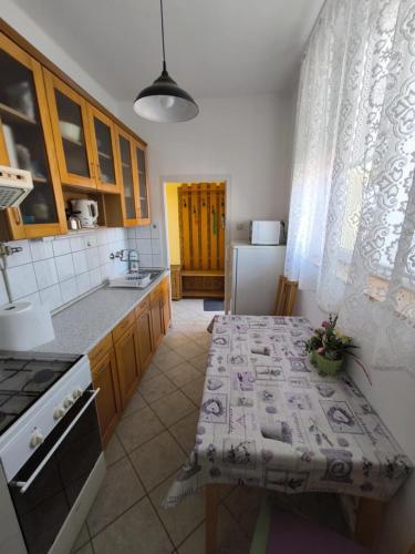 a kitchen with a table with a table cloth on it at Szeki Apartman in Balatonfüred