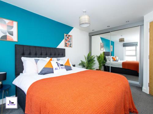 a bedroom with a large bed with an orange blanket at Carnforth by Alt-Stay - Wakefield 2 Bed Ensuite Townhouse Contractor and Corporate Accommodation with Private Balcony, Parking, Smart TV, Kitchen and Fast Wi Fi - Long Stay Ready with Weekly and Monthly Rates in Wakefield