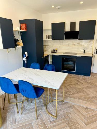 une cuisine avec une table blanche et des chaises bleues dans l'établissement MOON - 34, à Nice