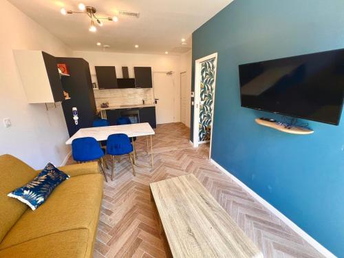 - un salon avec un canapé et une table avec des chaises bleues dans l'établissement MOON - 34, à Nice