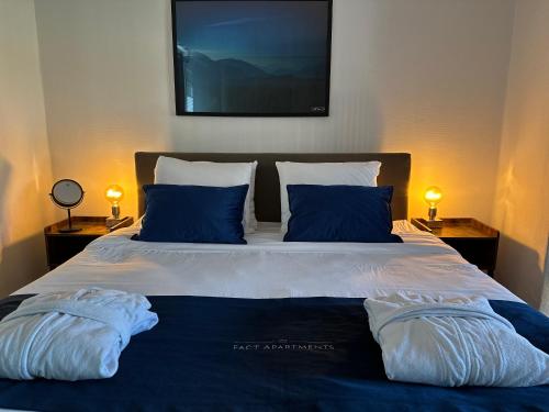 a large bed with two pillows and a picture on the wall at FACT Apartments in Arnoldstein