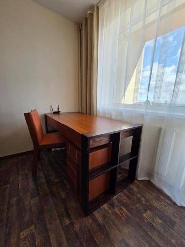 a desk with a chair in a room with a window at Apartment High Tatras in Veľký Slavkov