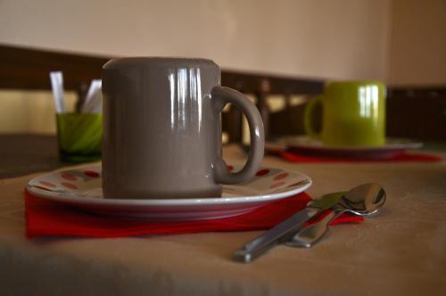 a coffee cup on a plate with a pair of scissors at Le Provence in Manosque