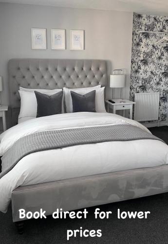 a bedroom with a large bed with a book direct for lower prices at Chadberry House Hotel in Blackpool