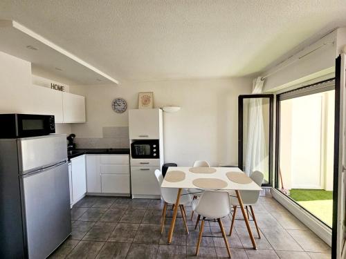 une cuisine avec une table et des chaises dans une pièce dans l'établissement Studio climatisé centre port avec Piscine & Parking, au Cap d'Agde
