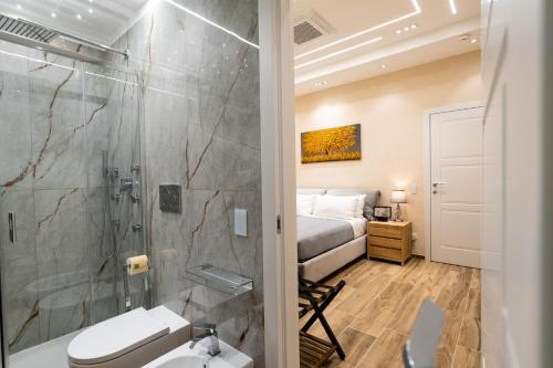 a bathroom with a shower and a toilet and a bed at Paci Luxury Suite in Rome