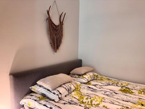 a bedroom with a bed with a headboard and antlers on the wall at Nordic Sauna Experience in Helsinki