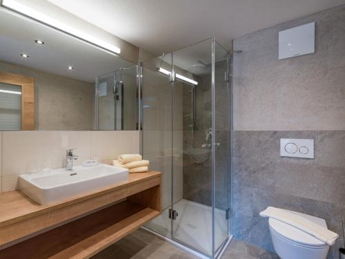a bathroom with a shower and a sink and a toilet at Apartments Rosenhof in Mayrhofen