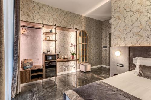 a bedroom with a bed and a desk and a television at Apollo Boutique Hotel in Rome