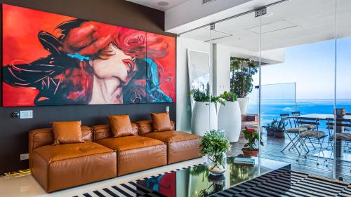 un salon avec un canapé brun et un tableau dans l'établissement Avalon - 1004 Stunning Luxury 3 BR Private Pool, à Puerto Vallarta