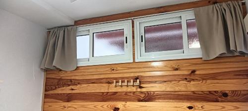 two windows in a room with a wooden door at Apartamento Calella Home in Calella de Palafrugell