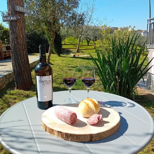 a table with wine glasses and a plate of food at Villa Nonno Nicola in Montenero di Bisaccia
